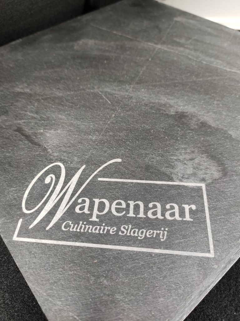 Logo op serveerplank van leisteen · 2